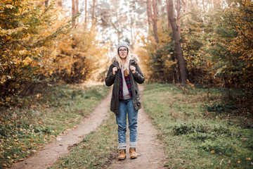 Obraz premium Hiking and travel along in the forest. Concept of trekking, adventure and seasonal vacation. Young woman walking in woods.