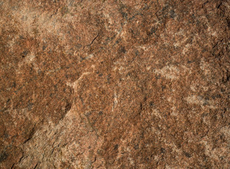 Background of natural stone. A snapshot of granite boulder (Latin "granum" - grain). Quartz crystals, plagioclase, potassium feldspar and mica are visible. Location at Lake Ladoga. Spring, sunny eveni