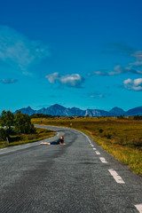 Girl in blue dress laying on the road  in  Straumnes
