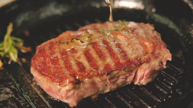 Restaurant cooking recipe. Pork sirloin. Chef pouring meat juices on roasting steak.
