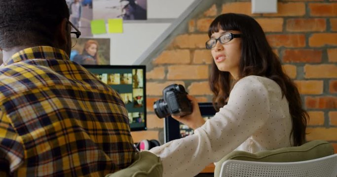 Graphic designers working together at desk in a modern office 4k