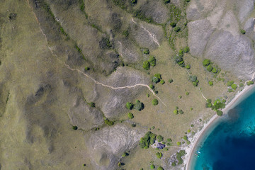 Seen from a bird's eye view, a rugged island is fringed by beach and reef in Komodo National Park, Indonesia. This tropical area is known for its marine biodiversity as well as its dragons.