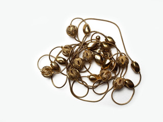 Beads of gold color jewelry on a white background