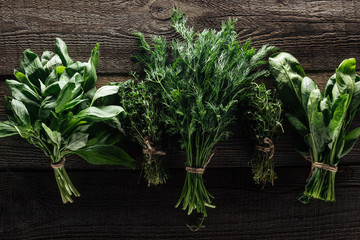 top view of green thyme, spinach, basil and dill on wooden weathered table