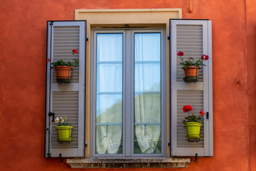 finestra in legno grigio con vasi di fiori 