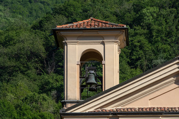 campanile con sfondo montagne e boschi