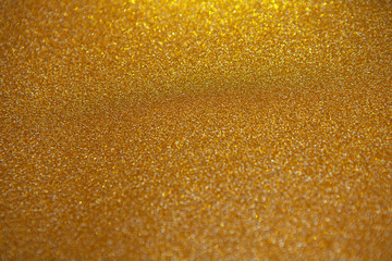 Abstract gold blurred background with numerous colourful bright festive bokeh. Soft selective focus. Texture with copy space for text. Celebration, holidays concept. Horizontal.