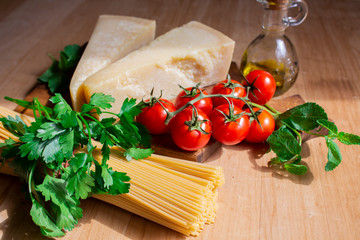 spaghetti with cheese, cherry tomatoes and mint. ingredients for pasta. spaghetti on wooden...