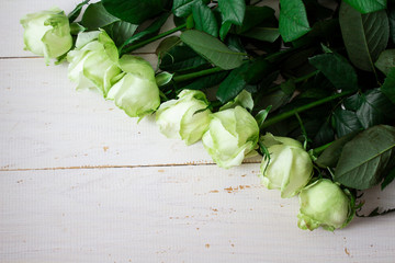 White roses on a white wooden background. space for text