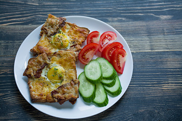 Grilled sandwich with egg, vegetables and bacon on a dark wooden background. Tasty breakfast.