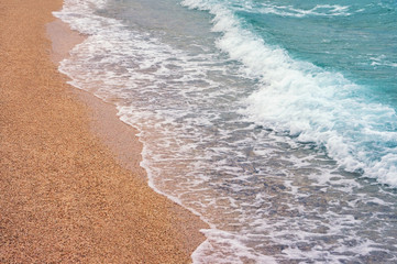 Wave on a sandy beach on a calm day. Montenegro, Adriatic Sea, Kotor Bay