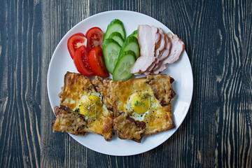 Grilled sandwich with egg, vegetables and bacon on a dark wooden background. Tasty breakfast.