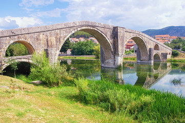 Fototapeta na wymiar Ancient stone bridge. Bosnia and Herzegovina, Trebinje city. View of Arslanagic ( Perovic ) Bridge over Trebisnjica river