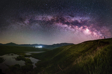 Fototapeta na wymiar The space of the universe. Beautiful panoramic view of the the lake and mountain with Milky Way galaxy. 