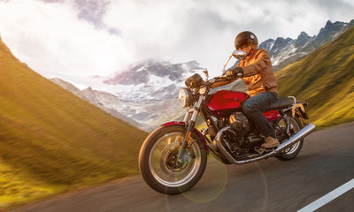 Motorcycle driver riding in Alpine highway, Nockalmstrasse, Austria, central Europe.