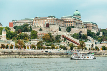 View on Buda Hill among green trees and Danube River on which the ship sails