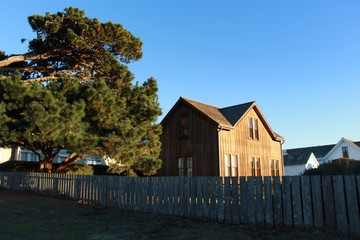 Traditional wooden house on the lake with wooden fence big tree and blue sky summertime in California