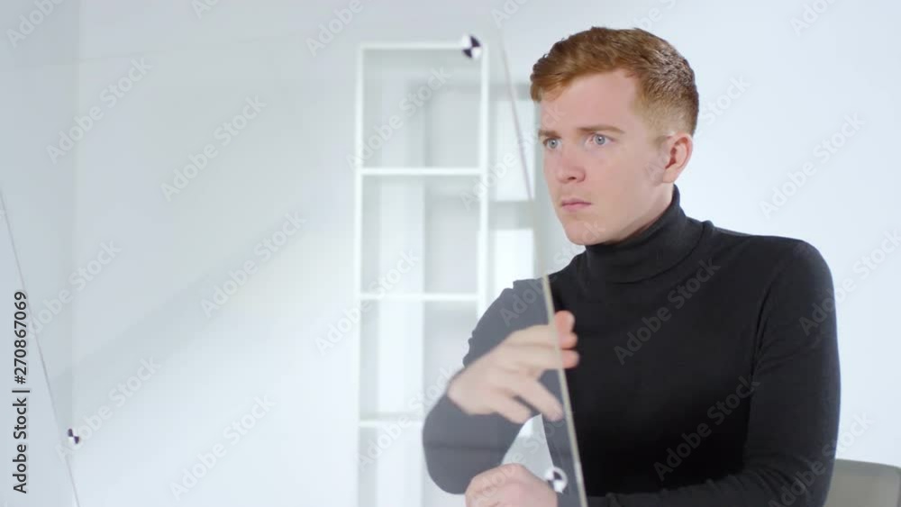 Aufkleber lockdown of young caucasian businessman sitting at invisible interactive screen, tapping and swiping