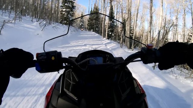Snowmobiles driver meets another riders on road and says hello to them. Point of view clip as snowmachine driver travels on snowy road and says hello to other  skimobile riders moving on the same road