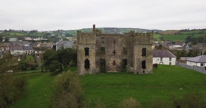 Raphoe Castle, the Bishops Palace, standing on hill near Ireland town, Aerial pan 4k