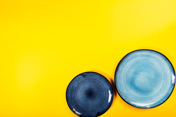 Empty Blue Plates on Bright Yellow Background, Top View, Copy Space
