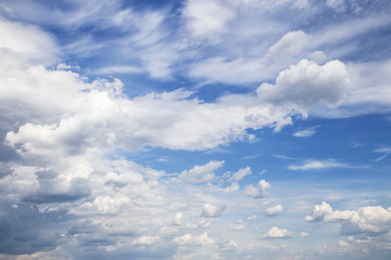 Cumulus fluffy white clouds in sunlight against blue sky background, heaven