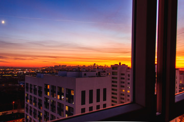 City on Sunset from close windows.City skyline in the dusk. Amazing panoramic view of modern city from high rise building