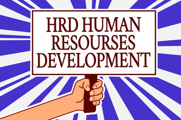Text sign showing Hrd Human Resources Development. Conceptual photo helping employees develop personal skills Man hand holding poster important protest message blue rays background