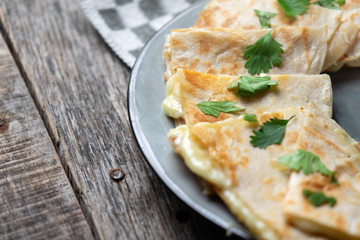 Mexican quesadillas cutted in triangle with flour tortillas and red sauce