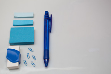 Materials on white table, pen, message blocks, paper clips, rubber and page markers