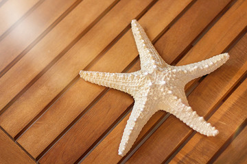 Starfish on a wooden background, chaise longue, mockup, mockup. Hello summer. The concept of leisure, travel. Selective focus, close-up.