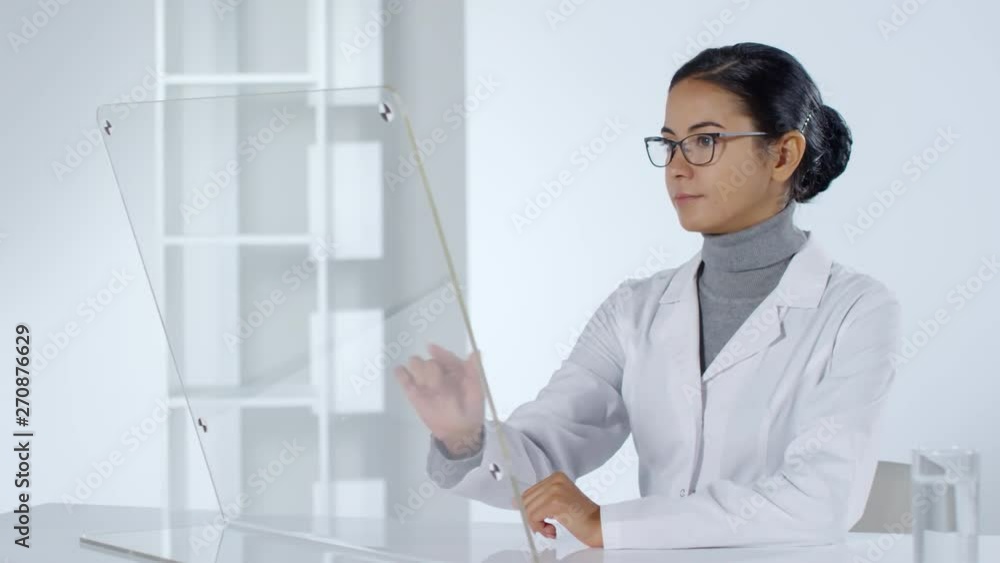 Aufkleber lockdown of middle eastern female doctor in lab coat swiping on futuristic computer with glass monit