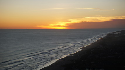 the sun sets in the summer on the shore of the orange sky