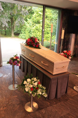 A coffin with a flower arrangement in a morgue