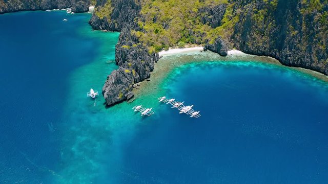 Aerial view of diving boats near secret lagoon on Miniloc Island. El-Nido, Palawan. Philippines. Bizarre limestone rock formation and blue lagoon with coral reef make this place unique