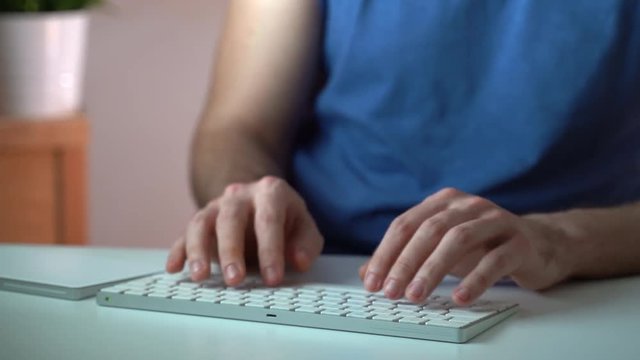 Young man hands typing on white keyboard in the evening light. Business conception
