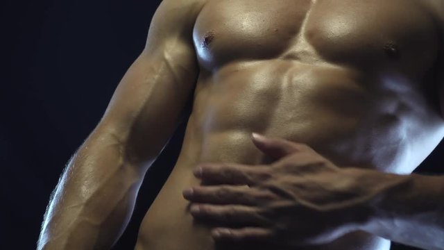 Young fit guy posing, showing abdominal muscles