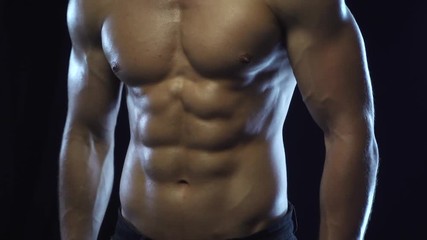 Young fit guy posing, showing abdominal muscles, slow motion