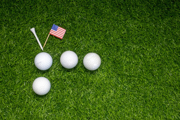 Golf ball with American flag on green grass