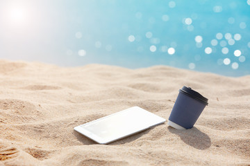 coffee paper cup with tablet put on the white sand beach - Summer relax  and marketing digital on line ,Holidays concept.