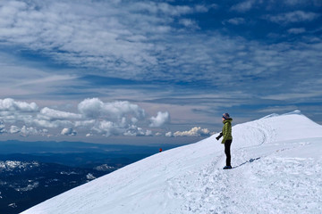 Woman hiker on mountain top looking at scenic view. Winter hiking and climbing. Mount Saint Helens summit. Seattle. Washington. United States of America