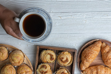 cup of coffee and shredded pork bun on wooden plate