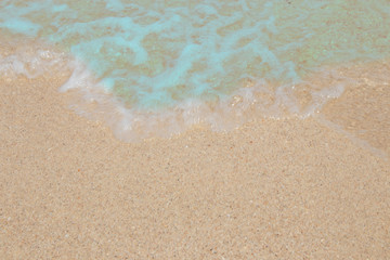 Fototapeta na wymiar Wave of blue ocean on sandy beach.