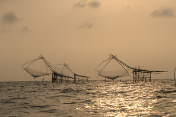 Fishing traps or square dip net in lake is local fishery with sunrise background at Pakpra Phatthalung province in famous tourist to travel at southern of Thailand