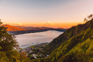 Batur volcano and lake with forest in Bali. Sunrise time in mountains