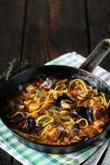 Keto Pasta Zucchini (noodles) Zoodles Spaghetti With Mussels In Tomato Sauce In A Frying Pan. Low-Carb keto. Spaghetti Tarantina. copy space. space for text. recipes for fatty protein foods 