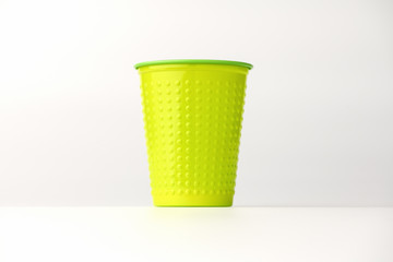 Plastic disposable Cup stands in the center on a white background. Isolated background. Cup with pimples.