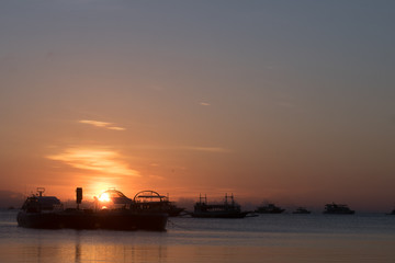 The beach with ships at the dawn