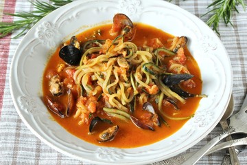 zucchini spaghetti with mussels in tomato sauce in a beautiful bright plate. keto pasta. Low-Carb