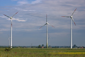 High wind turbines inTurbiny wiatrowe na tle nieba field